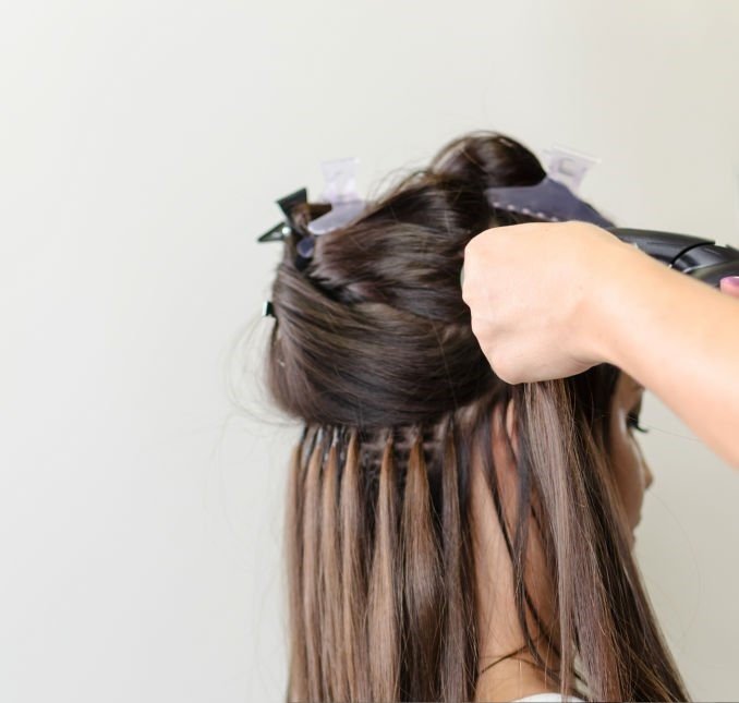 woman sitting on chair and make hair extension